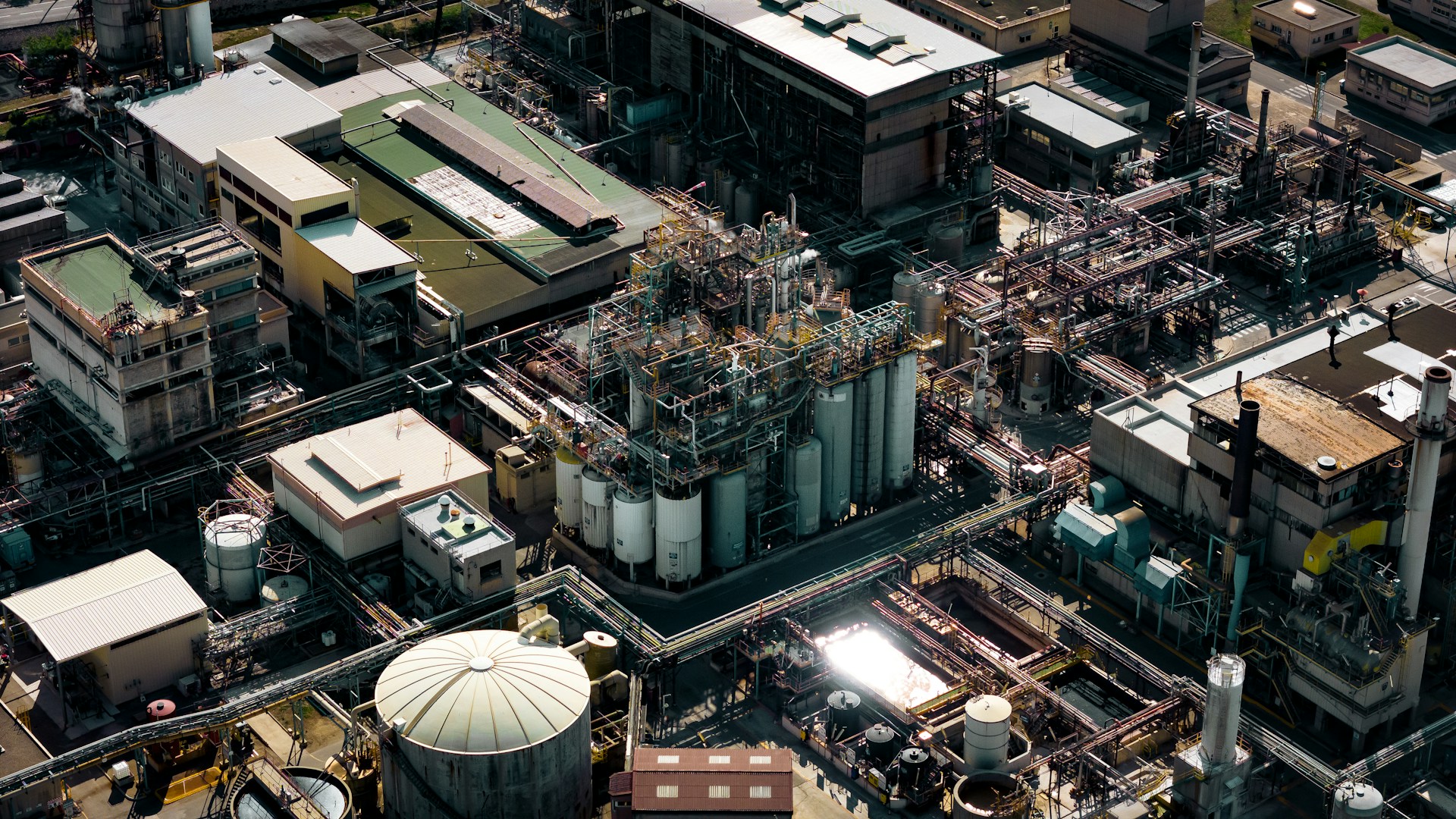 Aerial view of an industrial site with tanks and piping — evaporation technology context. Photo: XT7 Core on Unsplash.