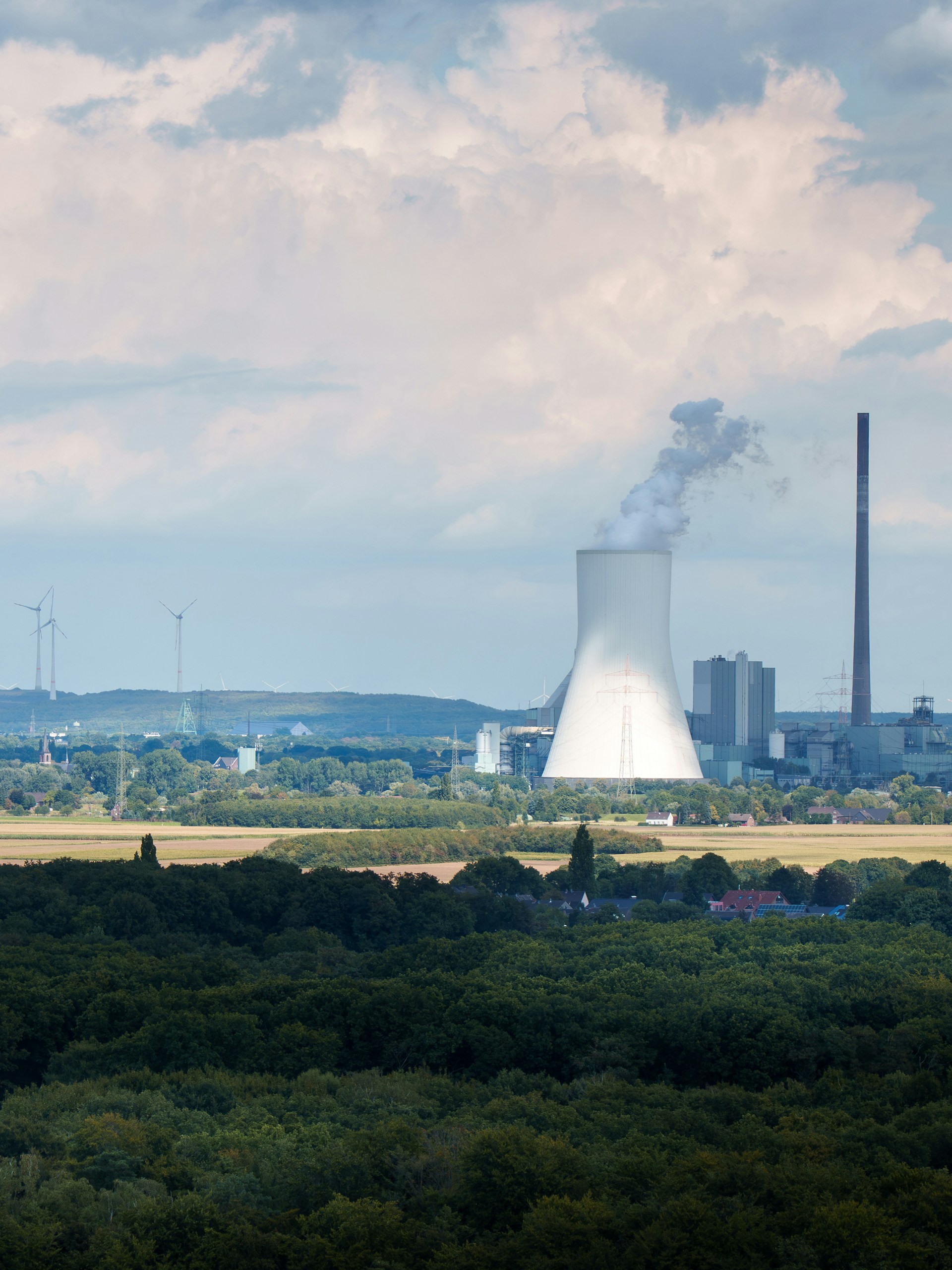 Cooling tower with steam at an industrial plant — evaporation and thermal process context. Photo: Jakub Żerdzicki on Unsplash.